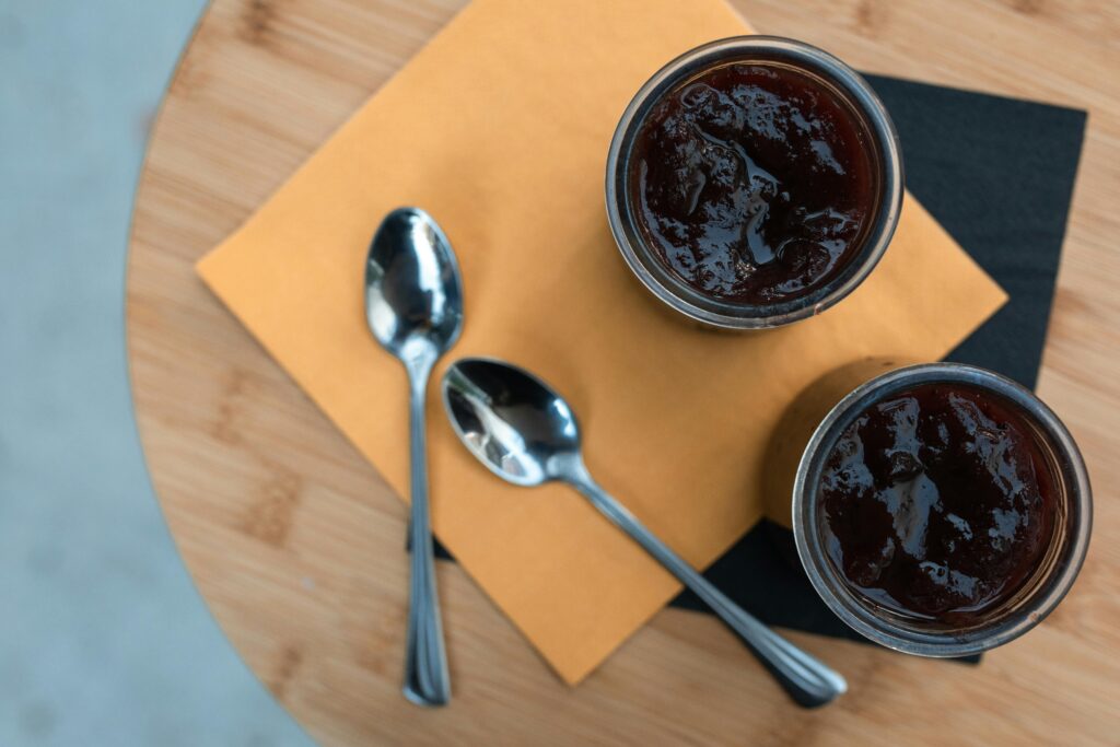 Delicious chocolate dessert served in jars with spoons, ready to enjoy on a wooden table.