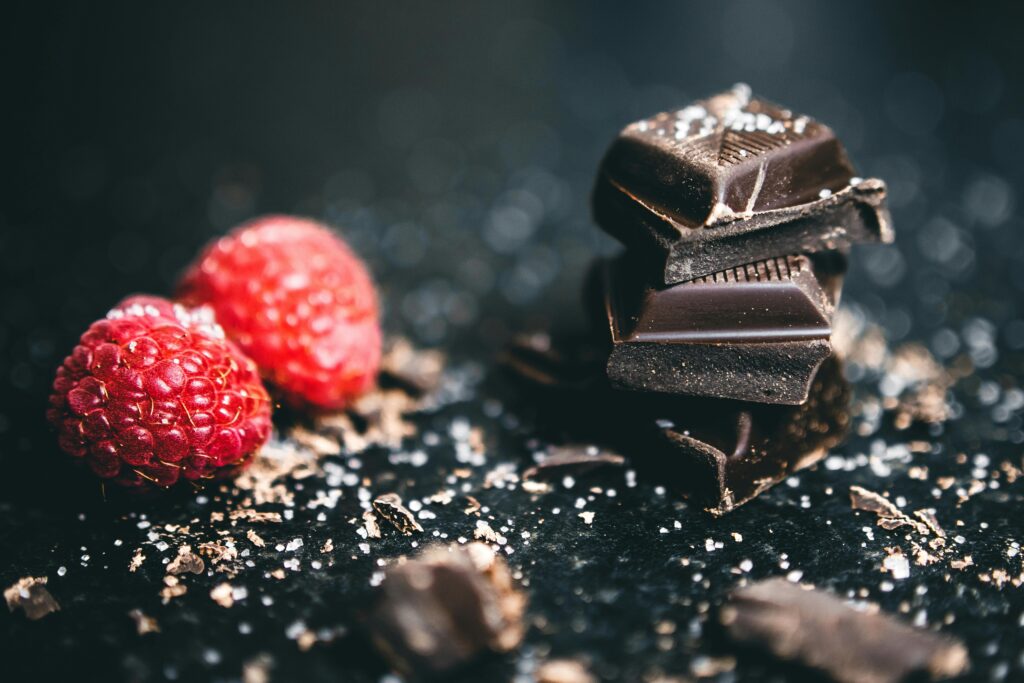 Close-up of dark chocolate pieces and raspberries, perfect for gourmet dessert ideas.